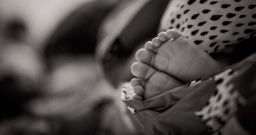 Black and white closeup photo of the baby’s feet in the mother’s arms, high resolution photography, insanely detailed, fine details, stock photo, professional color grading, award winning composition, natural light, cinematic lighting, in the style of a professional photographer. –ar 128:67