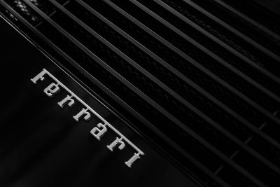 Black and white photography of the Ferrari logo on black grills in the style of a minimalistic aesthetic. --ar 128:85