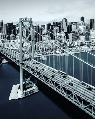 aerial view of the san francisco bay bridge with city in background, monochrome, hyper realistic photography --ar 51:64