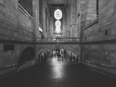 Black and white photography of Grand Central Station in New York City, shot from the perspective on someone walking through it. --ar 4:3