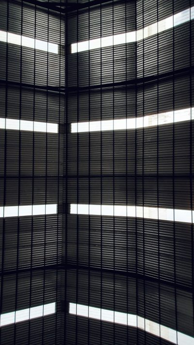 Black metal slats, vertical stripes of light shining through, inside the glass ceiling of an art museum in Tokyo. Minimalist background, high resolution, hyper realistic photography, award winning photo --ar 9:16