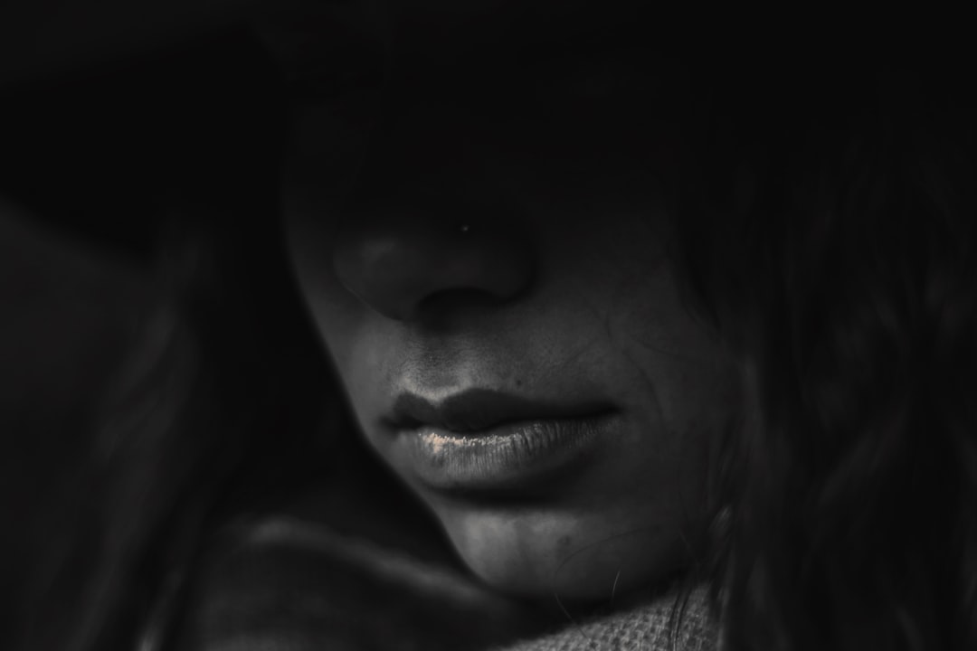 A closeup of the face, focusing on her lips and nose, illuminated by soft moonlight, creating an atmosphere. The monochromatic color scheme adds depth to the composition. –ar 128:85