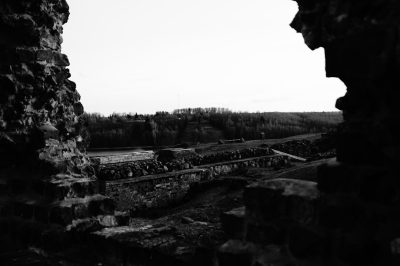 view from inside of old castle ruins, overlooking countryside landscape, black and white photography, dark, gritty --ar 128:85