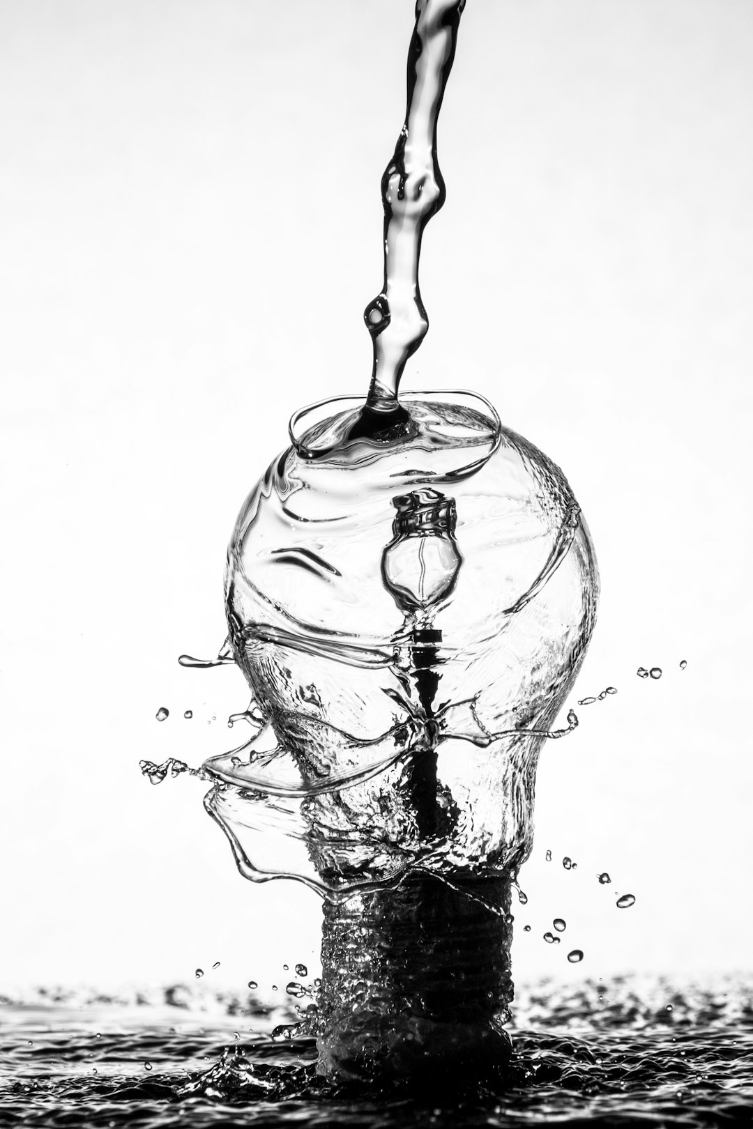 light bulb made of water, water pouring from above, white background, simple, high contrast, black and grey, surrealism, photo realistic, photography, wide angle lens, hyper realism, detailed monochrome photography, extreme close up, in the style of macro photography, monochrome, detailed, –ar 85:128