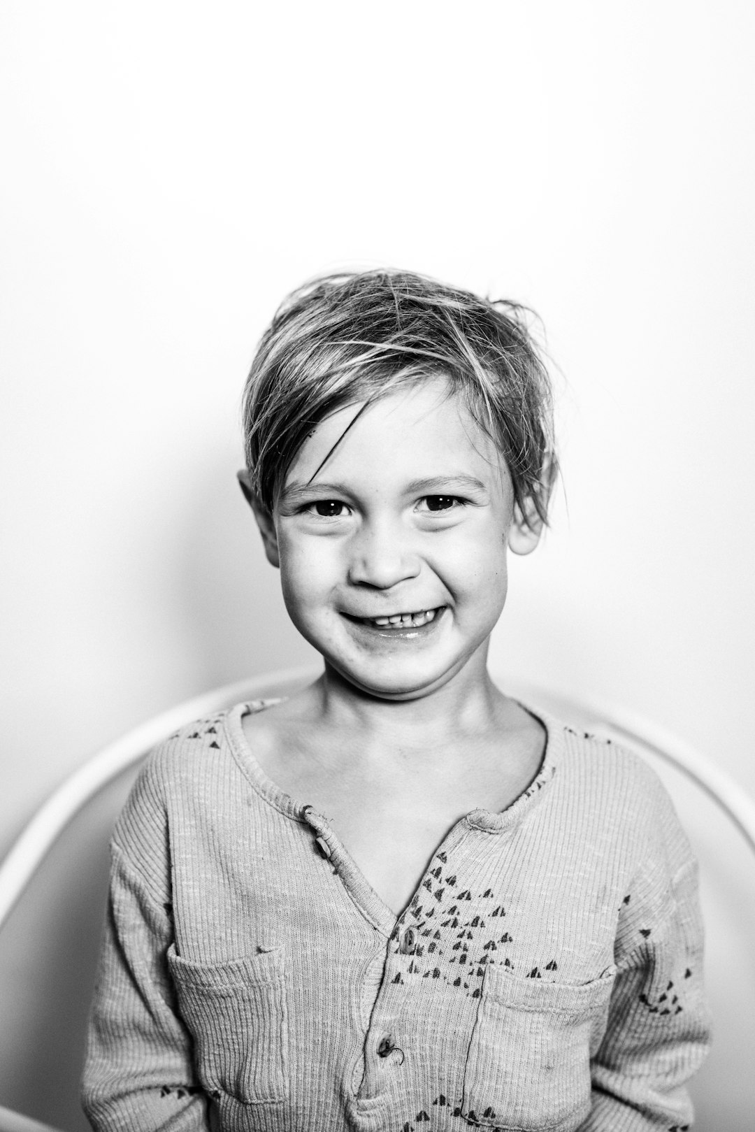 black and white portrait of smiling boy, short hair in the style of [Rineke Dijkstra](https://goo.gl/search?artist%20Rineke%20Dijkstra) photo, studio background, simple with dirty stains –ar 85:128