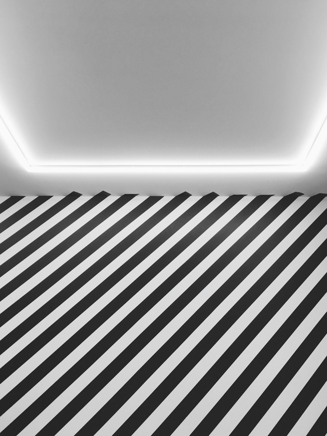 A white room with black and grey stripes on the floor, ceiling light, hyper realistic, minimalistic, photography, no people, low angle shot, high resolution, high detail, –ar 3:4