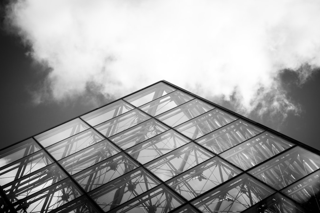 Black and white photography of the glass pyramid at louvre, clouds, minimalistic architecture –ar 128:85