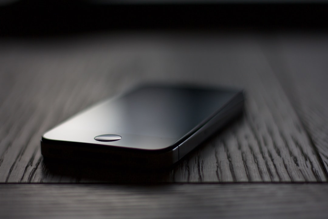 A close-up shot of an iPhone on a table, with a dark grey background and soft lighting, taken with high resolution photography, with insanely detailed and fine details, isolated on a black background, in the style of stock photography. –ar 128:85