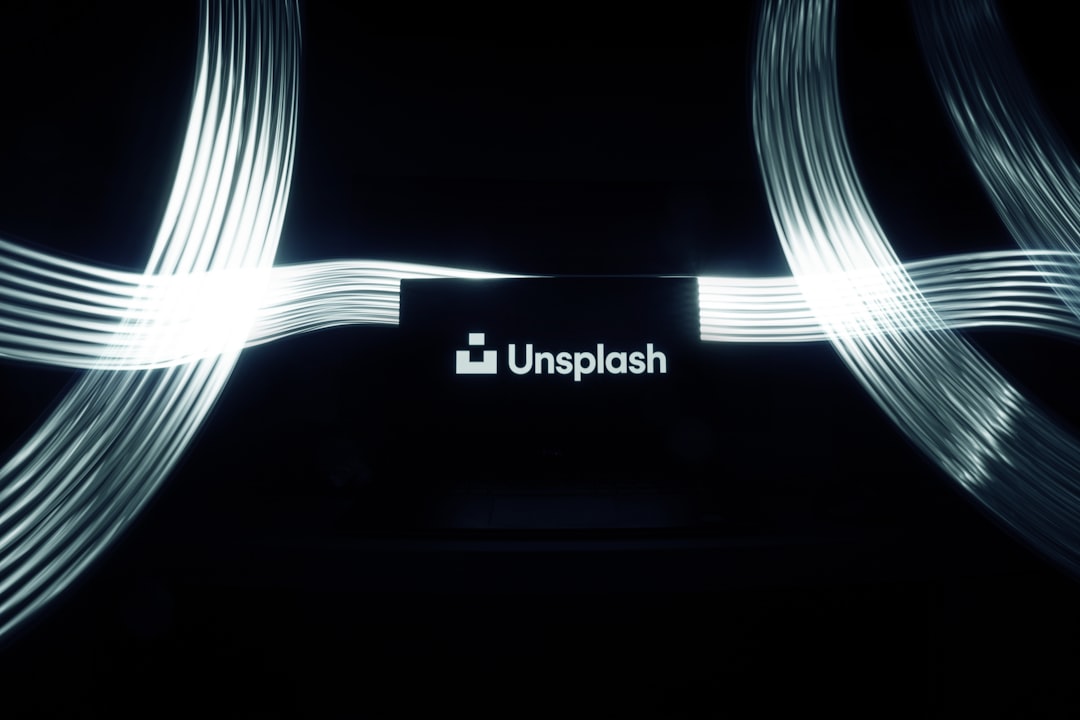 A logo with the text “Un splash” written in white on a black background, light beams coming from behind it in the style of Apple’s design, with the brand name “Un splash”, surrounded by glowing lines that create visual depth and texture, creating a sense of mystery and luxury. The overall atmosphere is sleek and modern, with high contrast lighting that highlights intricate details. –ar 128:85