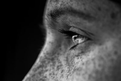 Close up of a man's eye looking away, in black and white, with high contrast, showing detailed skin texture, with studio lighting, done in the style of macro photography, using a Nikon D850 camera with a 24-70mm lens at f/3.6, resulting in a shallow depth of field. --ar 128:85