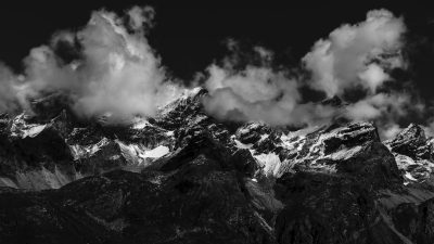 Black and white photo of the Himalayas, high contrast clouds above mountains, shot with Sony Alpha A7 III, black & white, high resolution, hyper realistic, national geographic photography, in the style of National Geographic. --ar 16:9