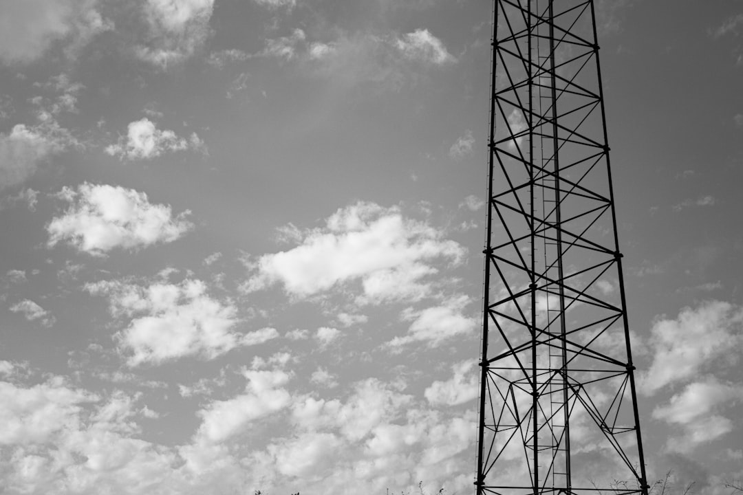 Black and white photography of an old radio tower, neutral background with clouds, highly detailed, high resolution, shot on Sony A7 III by Fuji film + fujifilm lens , 80mm focal length –ar 128:85