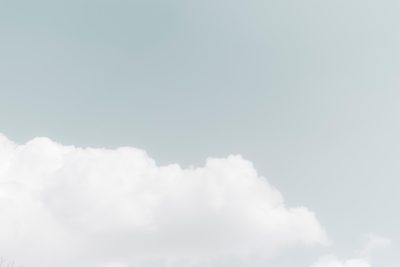 Photo of a white cloud in the sky, against a pastel background, in a high quality style, in the style of unsplash photography, with a minimalist style, using pastel colors of light blue and gray. --ar 128:85