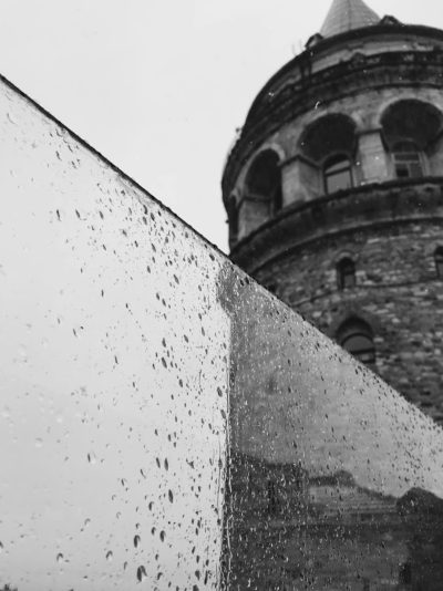 Galata Tower in Istanbul, black and white photography, rainy day, water drops on the glass. --ar 95:128