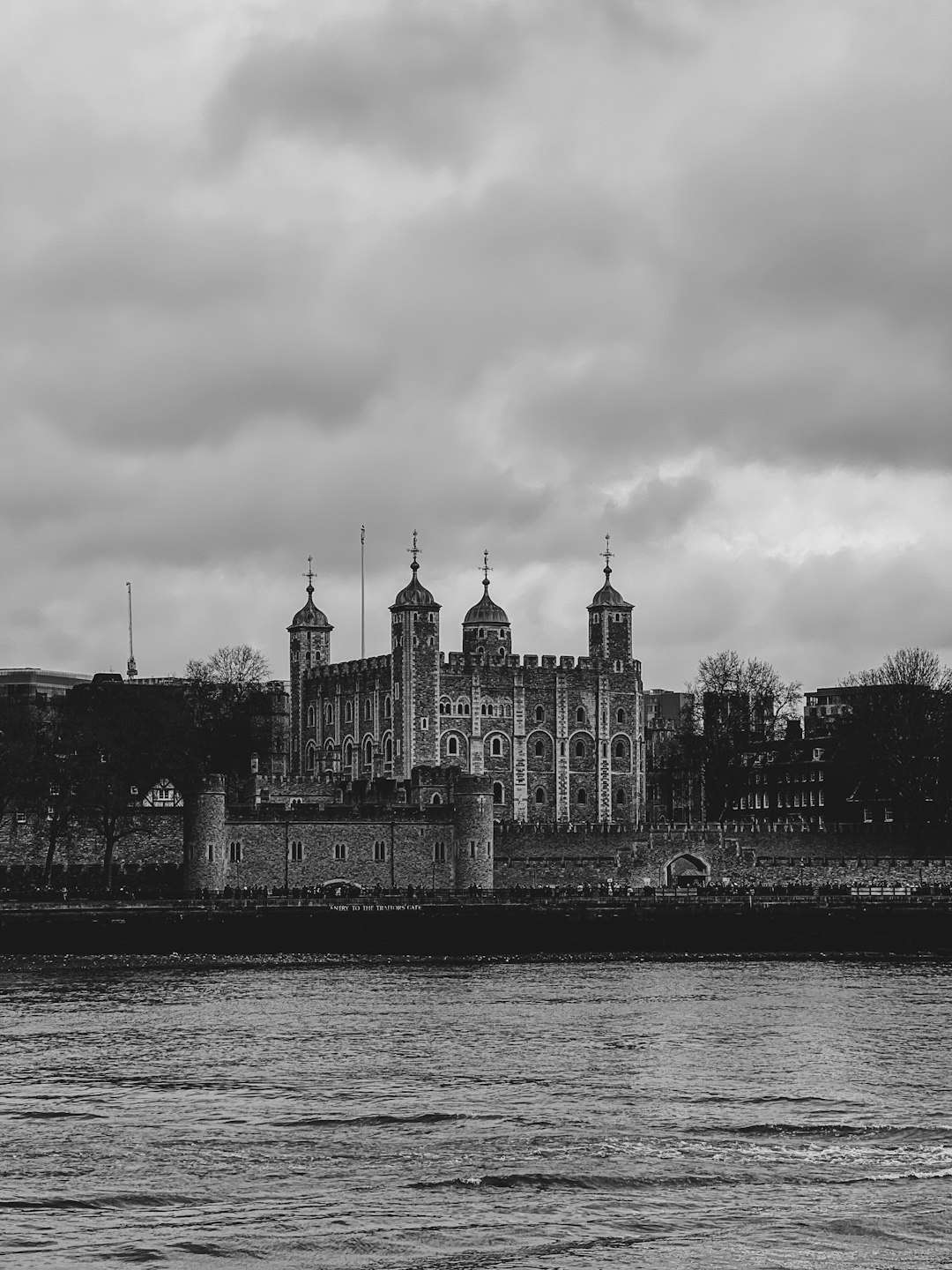 Black and white photography of the Tower of London, view from across the River Thames, minimalist style, cloudy day, travel photo. –ar 3:4