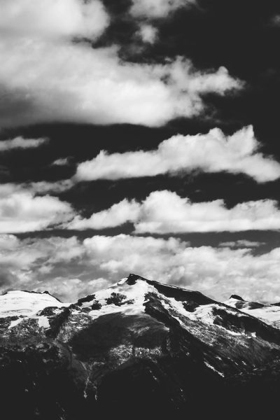 Black and white photography of the peak top of Whistler Mountain with clouds in the background, high contrast, sharp details, simple. --ar 85:128