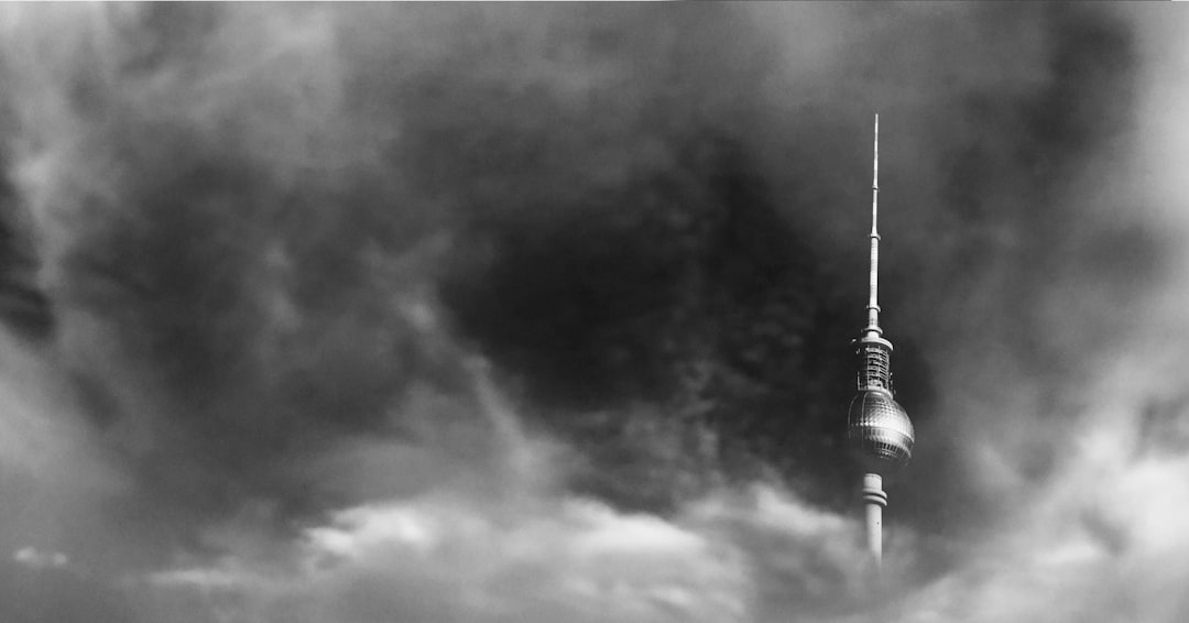 berlin fernsehturm in the clouds, black and white photography, grainy filmic –ar 128:67