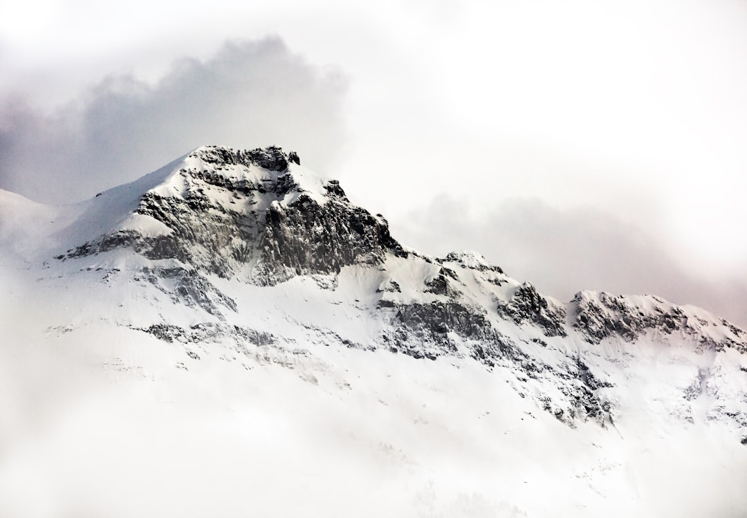 Snowy mountain peak seen through clouds, white background, photorealistic, high resolution, –ar 16:11