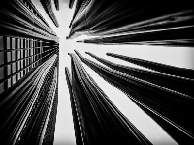 Black and white photography, perspective of skyscrapers that look like long thin canes pointing upwards from a low angle shot, taken with a Canon EF 24-70mm f/2.8L III lens in the style of typical city photography. --ar 4:3