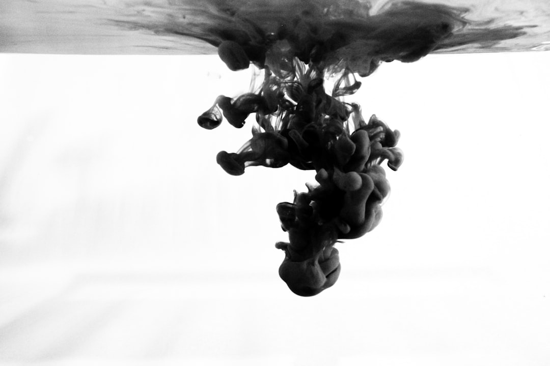 Black ink in water, white background, suspended at the bottom of the screen, smoke like clouds, ink spreading from top to down –ar 128:85