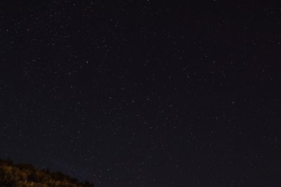 Starry night sky, the Big Rock and distant stars are visible, the dark sky has no clouds, the clear sky is in sharp focus with high resolution. Captured in the style of Canon EOS at f/8, ISO 200, the soft lighting has low contrast without grainy textures, with sharp details on the full frame. --ar 128:85