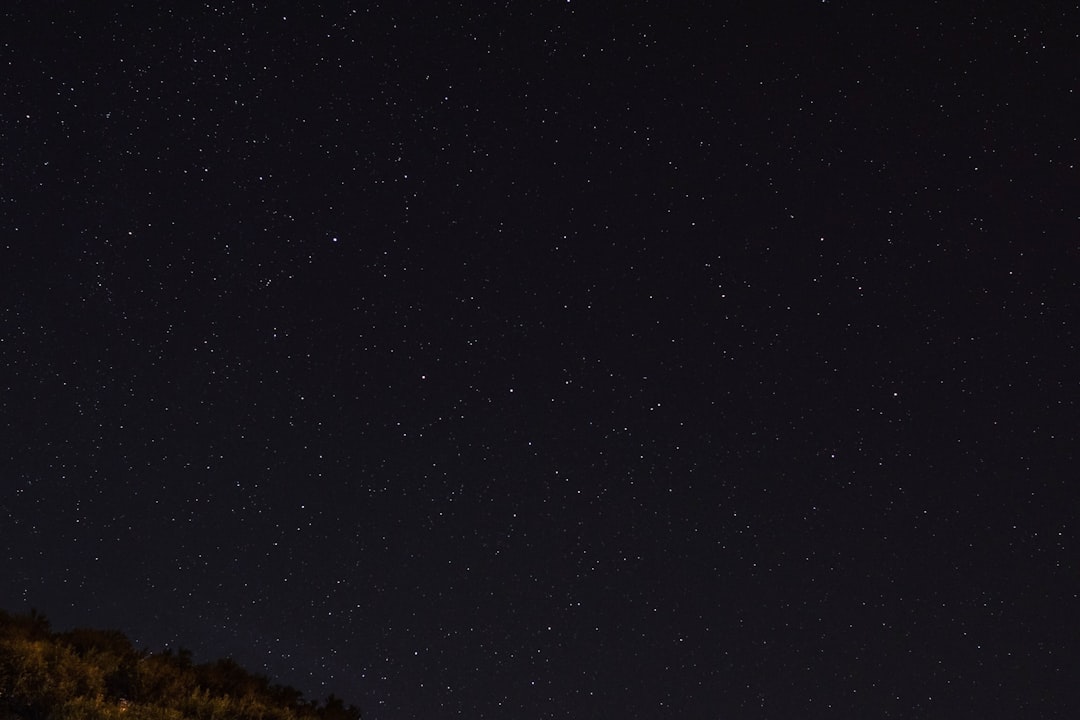 Starry night sky, the Big Rock and distant stars are visible, the dark sky has no clouds, the clear sky is in sharp focus with high resolution. Captured in the style of Canon EOS at f/8, ISO 200, the soft lighting has low contrast without grainy textures, with sharp details on the full frame. –ar 128:85