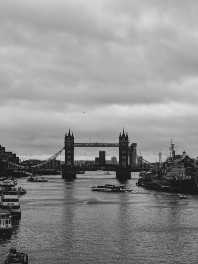 London Tower Bridge, black and white, River Thames, no boats, no people, city in the background, cloudy sky, shot in the style of Sony Alpha A7 III --ar 3:4