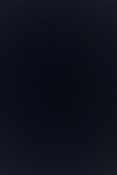 A flat, dark blue sky without any stars or other objects. The background is completely black and uniform in color with no patterns or textures visible on the surface of it. There's nothing else but for one small star to be faintly illuminated at the bottom right corner of frame. This creates an atmosphere of solitude and calmness. It would work well as a background texture for various creative projects that need a minimalist yet striking effect. --ar 85:128