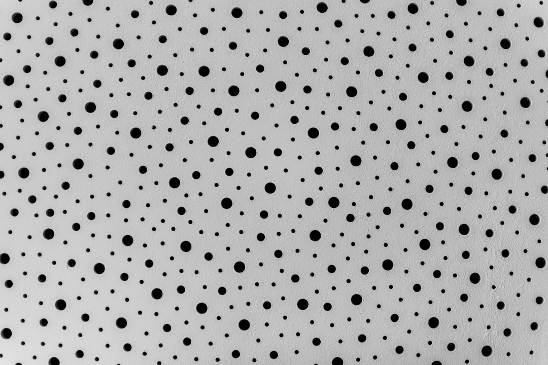 Black dots on white background. Texture of paper with holes. Abstract background. Black and White. Minimalist pattern. Flat lay, top view –ar 128:85