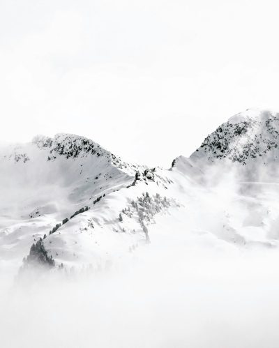 White snow covered mountains, foggy with a white background, simple and minimalistic in style. The photography has a cinematic quality with high resolution and high detail, featuring sharp focus. It has the appearance of a studio photo shoot with high quality. --ar 51:64