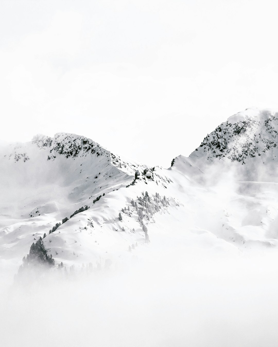 White snow covered mountains, foggy with a white background, simple and minimalistic in style. The photography has a cinematic quality with high resolution and high detail, featuring sharp focus. It has the appearance of a studio photo shoot with high quality. –ar 51:64