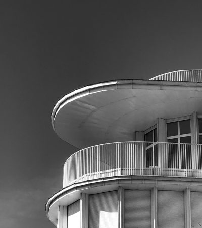 modernist architecture, modernism, art deco building with round roof and white balcony, black & White photography, high contrast, 35mm lens at f/8 aperture setting --ar 113:128