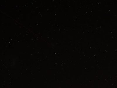 wide shot of black sky with few stars, one very thin and long red comet in the upper left corner --ar 4:3