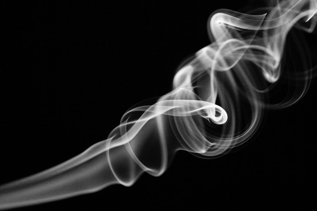 A closeup of swirling white smoke against a black background, capturing the fluidity and beauty in its movement. The focus is on creating an abstract composition with soft lines and curves that suggest motion and depth. This visual metaphor for energy or life could be used as a design element to convey artificial intelligence’s complexity and dynamic nature in the style of abstract expressionism. –ar 128:85