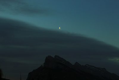 Night, crescent moon and dark sky over the mountain in Canada, distant view, telephoto lens, high definition photography, delicate light and shadow --ar 128:85