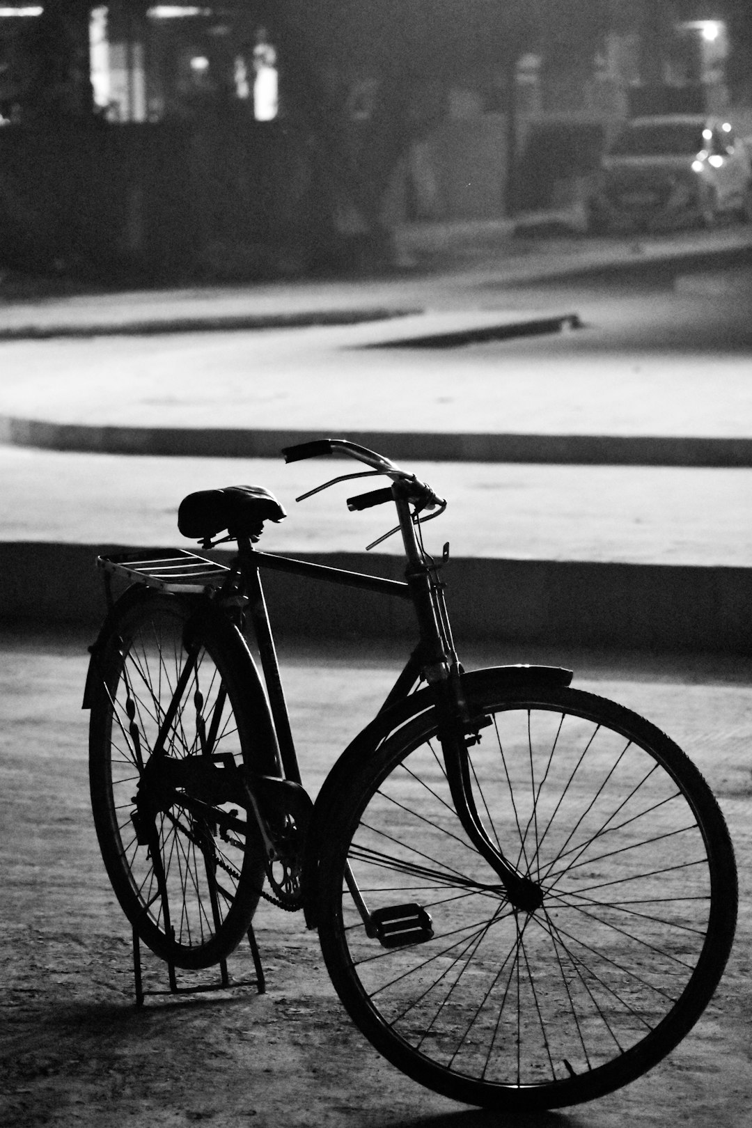 A vintage bicycle was parked on the street in the style of black and white photography, with soft lighting and a blurry background of an empty square in Shanghai at night. The bike was leaning against it, showcasing its classic design. A sense of nostalgia surrounded you as if time had come to rest in this city. –ar 85:128