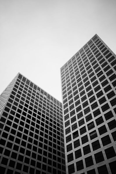 two tall buildings made of squares in a low angle shot, architectural photography in black and white --ar 85:128