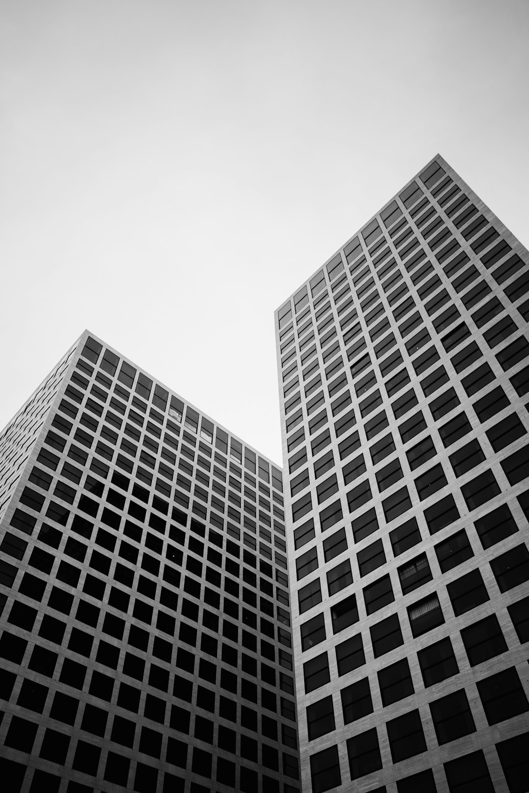 two tall buildings made of squares in a low angle shot, architectural photography in black and white –ar 85:128