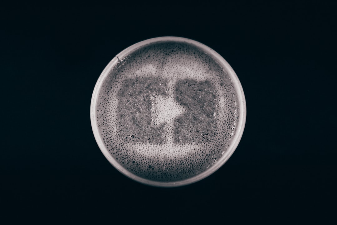 top view of cup with milk foam in the shape of an Instagram logo on black background, minimalism, photorealistic, high resolution photography –ar 128:85