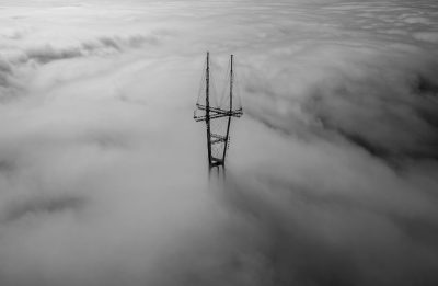 black and white drone photo of trans tornillol tower in the clouds --ar 128:83