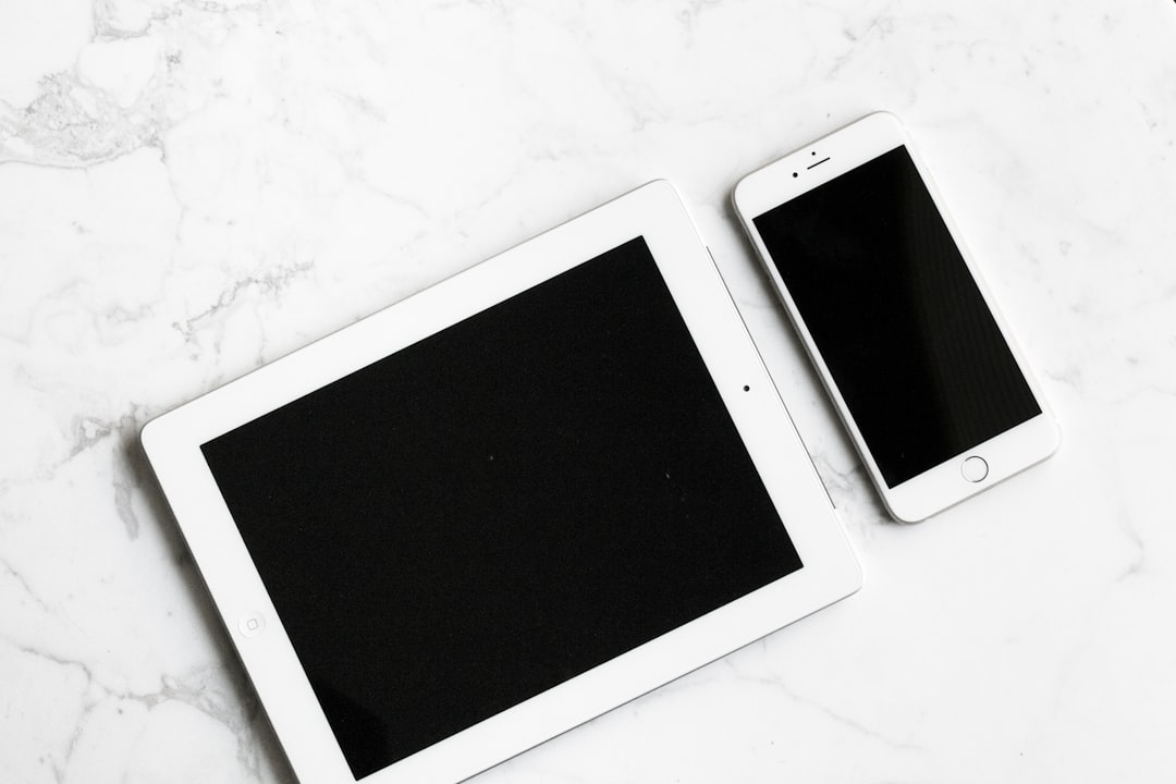 Photo of a tablet and phone on a white marble surface, in a flat lay style. Web banner with copy space on the right. –ar 128:85