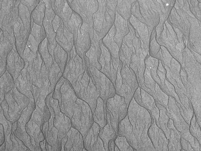 A high-resolution, detailed texture of sand ripples in black and white. The intricate pattern has visible lines on the surface, resembling fine patterns found at coastal beaches or shorelines. It is suitable for use as an abstract background or wallpaper design, offering a unique visual experience to any project that gives off natural elements. This textured background adds depth and realism while maintaining simplicity. --ar 4:3