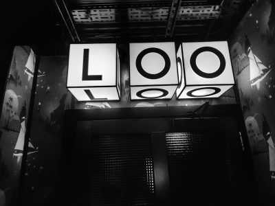 black and white photo of the word "LOO" in large letters on three glowing cubes, suspended above an immersive room with film posters, vintage movie posters, black background, cinematic lighting, atmospheric perspective, epic composition, volumetric light, hyper realistic, octane render, high resolution photography, photorealistic, shot by Hasselblad x2d camera, natural light, cinematic, editorial magazine --ar 4:3