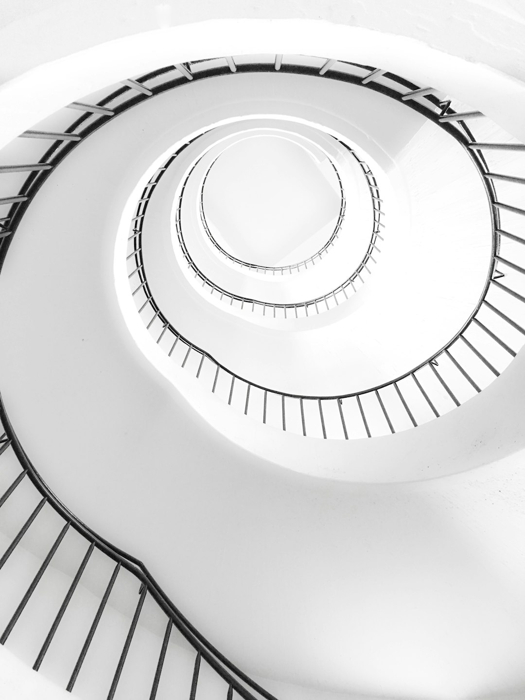 Spiral Staircase, white background, simple composition, black and white photography, architectural photography, symmetrical composition, minimalism, high angle view, closeup shot, soft light, in the style of minimalist. –ar 3:4