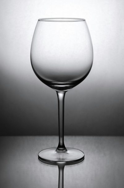 photo of wine glass on a solid grey background, lit by studio lighting, in the style of high resolution photography --ar 21:32