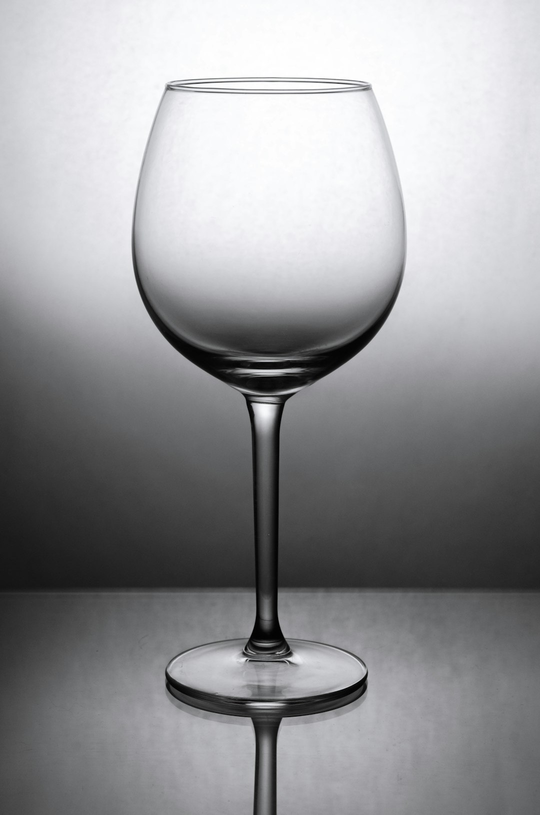 photo of wine glass on a solid grey background, lit by studio lighting, in the style of high resolution photography –ar 21:32