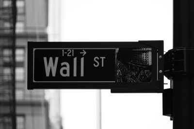 Black and white street sign with the text "wall st" on it, stock market photography, cityscape background, high resolution photography, captured in the style of Sony Alpha A7 III camera with Sony FE2485mm f/3.0 lens. --ar 128:85