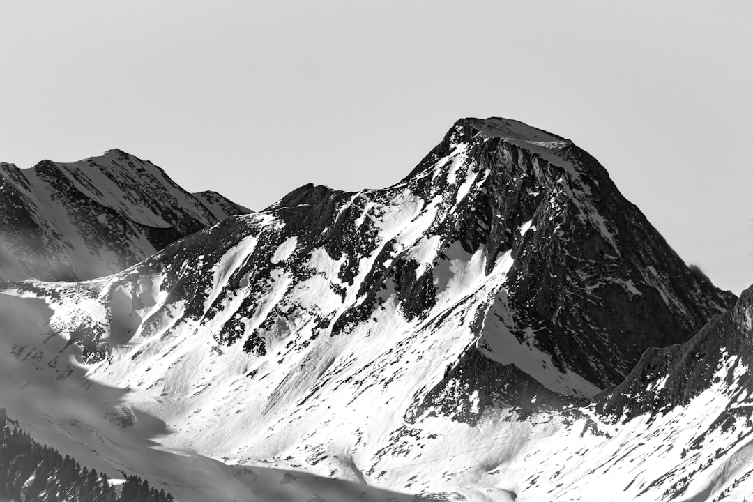 Black and white photo of snow-covered mountain peaks, with high contrast and sharp details. High resolution, high definition photography with stunning realism in the style of a professional photograph, taken in the style of a Sony Alpha A7R IV camera. –ar 128:85