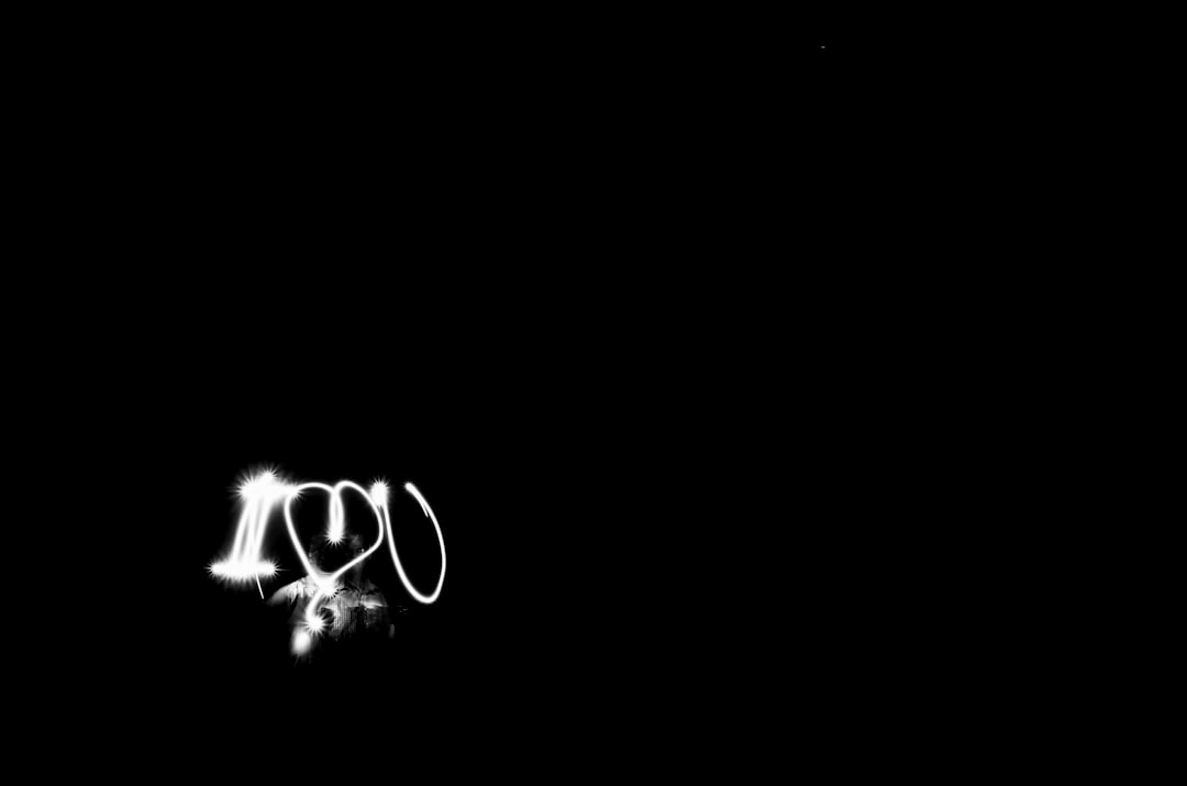 A minimalistic black and white digital drawing of the text “I love you” written in light on an all black background. The lighting is soft with no shadows. There is a thin glowing outline around each letter to make them stand out against the plain dark backdrop. In the style of modern art, with simple shapes and minimalism. It has a dreamy or fantasy feel to it. –ar 32:21