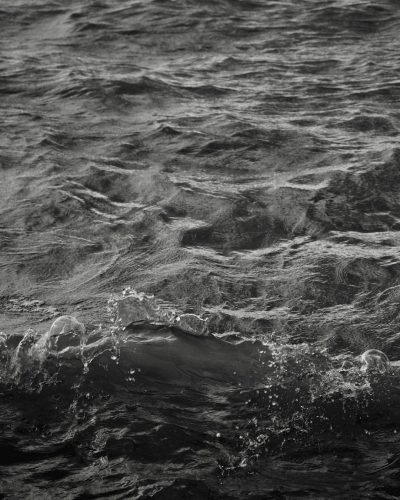 black and white photograph of the ocean, waves in the background, small bubbles visible on the surface, high contrast, dark tones, monochrome, high resolution photography, intricate details, detailed texture, natural lighting, professional color grading, depth of field, sharp focus, minimalistic style, in the style of [Misha Gordin](https://goo.gl/search?artist%20Misha%20Gordin). --ar 51:64